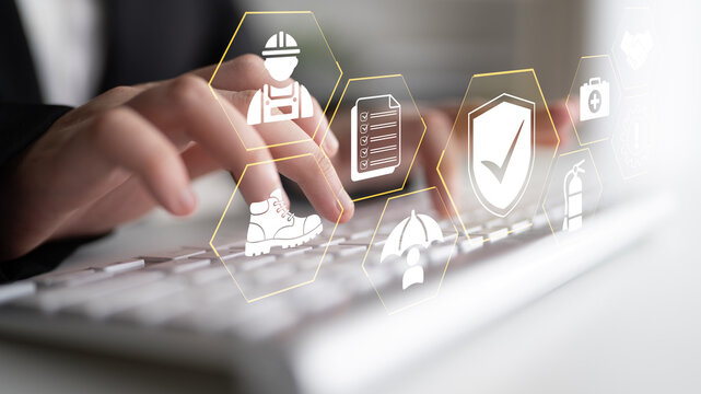 Hands typing on a keyboard with safety and productivity icons overlay, representing technology in workplace efficiency and occupational safety measures. Glyphic.