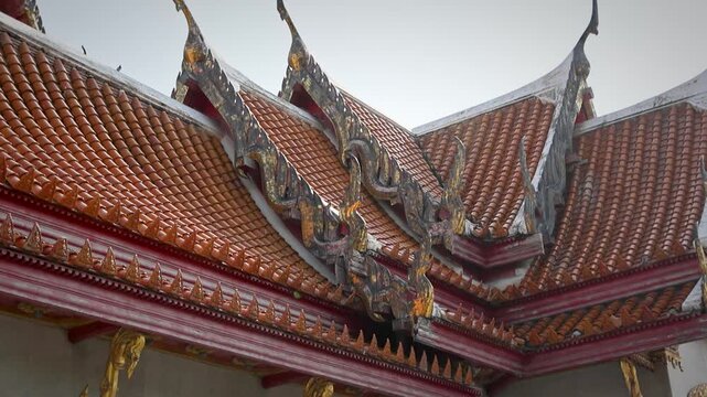 Ornate Red Tiled Temple Roof With Decorative Carvings And Gable Finials