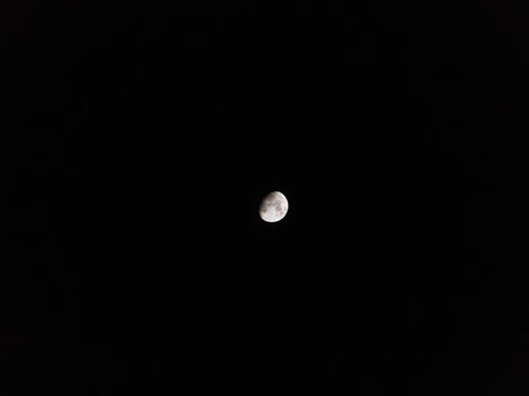 view of the waning gibbous moon or half full moon in the night sky