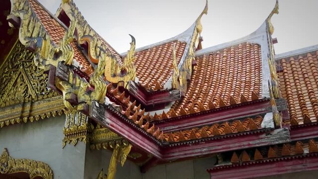 Ornate Temple Roof With Intricate Golden Carvings And Red Tiled Eaves