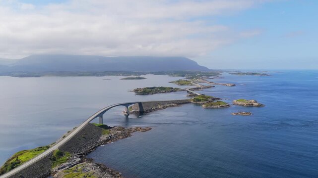Aerial drone view of the Atlantic Ocean Road in Norway. Winding highway bridge connecting islands across rough ocean waves during a scenic coastal road trip.