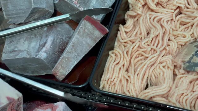 Assortment of fresh and frozen beef meat at market stall