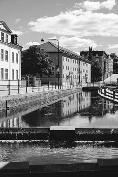 Black and white view of a city canal and weir