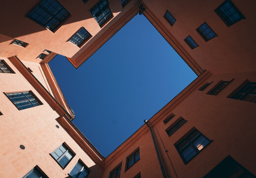 Low angle view of an inner courtyard framed by peach buildings