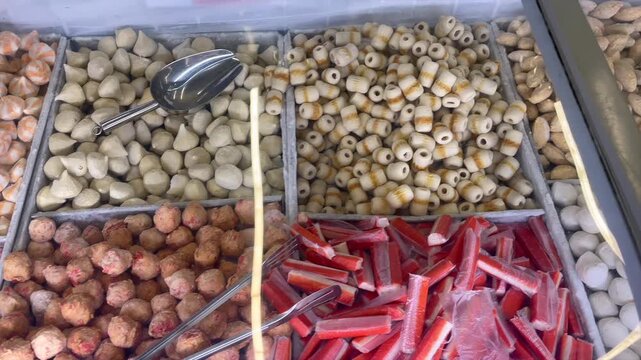 Assortment of raw frozen seafood and fish balls in supermarket display