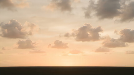Fototapeta premium Golden sunset sky with soft clouds. Beautiful evening horizon with warm orange light.