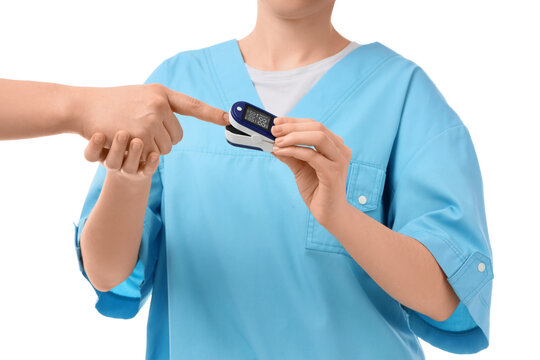 Medical professional in blue scrubs using a pulse oximeter on a patients finger for oxygen saturation measurement, this device measures oxygen saturation and pulse rate