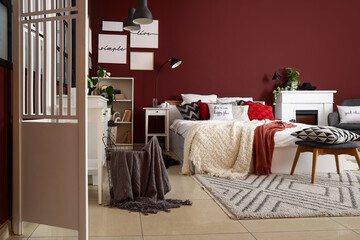 Obraz premium Interior of stylish bedroom with white folding screen, shelf unit and plants
