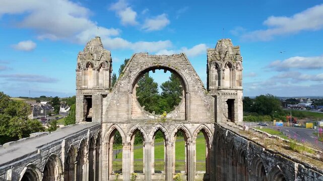 Slow panning camera movement inside the ancient Elgin Cathedral ruins, revealing preserved medieval stone walls, Gothic window frames, and central nave in Moray, UK