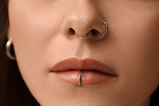 Pretty young woman with nose and lip piercing, closeup