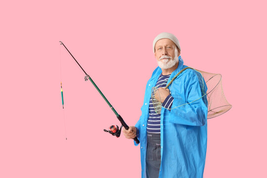 Senior man with fishing rod and keepnet on pink background