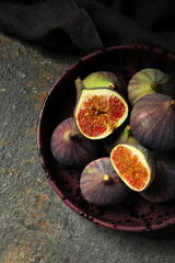 Obraz premium Bowl with fresh ripe figs on grunge background