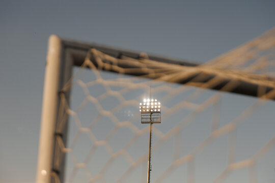 Football stadium floodlights shining at night, soccer match atmosphere and sports stadium illumination concept