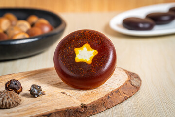 Jabón artesanal de cúrcuma con estrella amarilla iluminada sobre madera © ismartineza