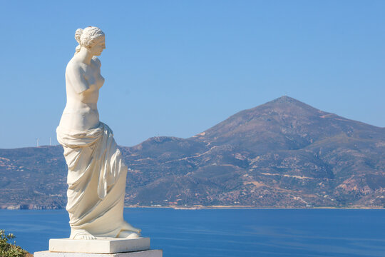 A marble statue inspired by Venus de Milo overlooks the Aegean Sea and mountains of Milos, Greece.