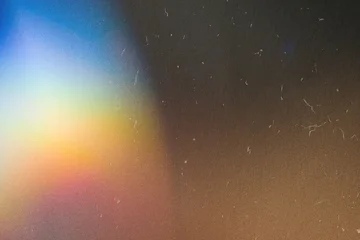 Abstract light leak creating vintage film grain and dust texture on dark background © colnihko
