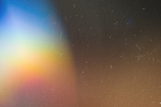 Abstract light leak creating vintage film grain and dust texture on dark background