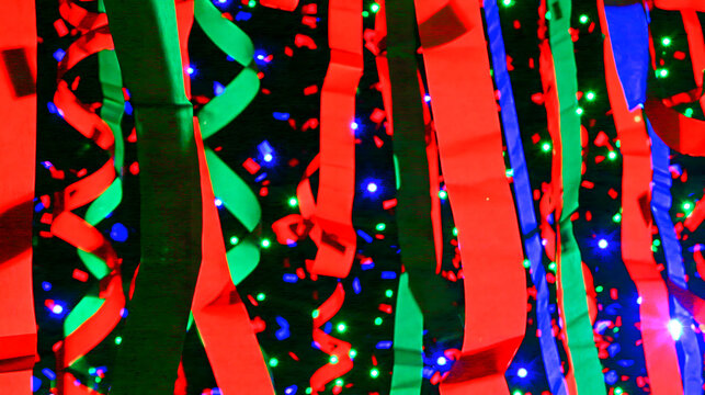 Colorful streamers in red and green with vibrant lights create a festive atmosphere.