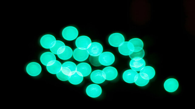 A collection of glowing green orbs, softly illuminated against a dark background, creating an enchanting, mystical mood.
