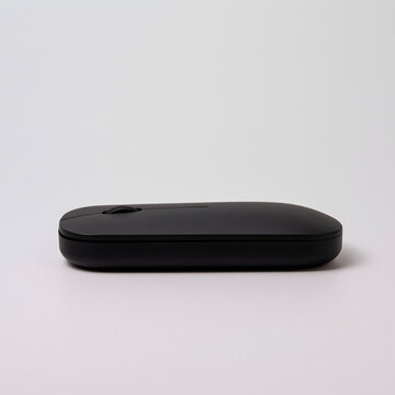 A sleek black computer mouse resting on a white surface, showcasing its modern design and streamlined shape.