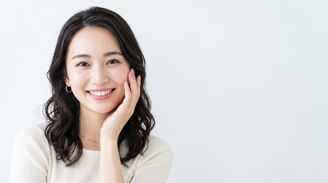 Young Japanese woman hand resting near her face in a cozy well lit interior, dermatology and healthy skin concept, ideal for skincare brand advertising