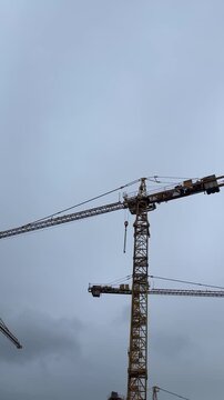 Two big cranes with a background of a blue sky. Construction industry job, working in construction, building process