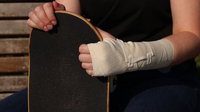Skateboarder's wrist bandaged with elastic bandage. Hand with bandage after falling from skateboard. Sprain, dislocation or bruise during active recreation. Wrist injury. Injury concept