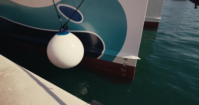 Close view of a catamaran fender hanging beside a moored passenger vessel at the waterfront in Zadar Croatia.