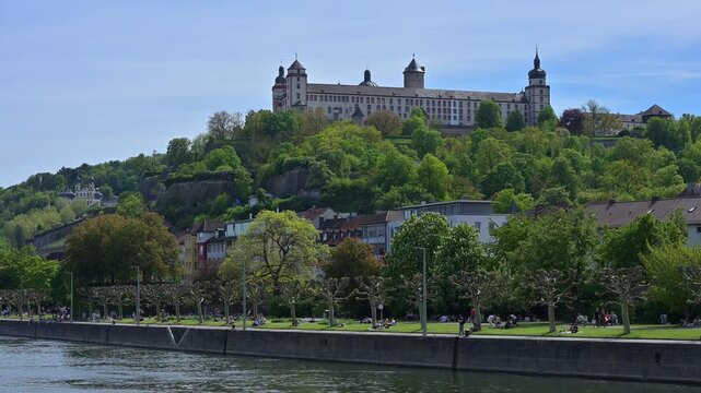 Gro&szlig;es Schloss auf H&uuml;gel &uuml;ber einer Stadt und einem Fluss, umgeben von &uuml;ppigen B&auml;umen unter klarem Himmel, Festung Marienberg, Main, W&uuml;rzburg, Mainfranken, Unterfranken, Bayern, Deutschland 