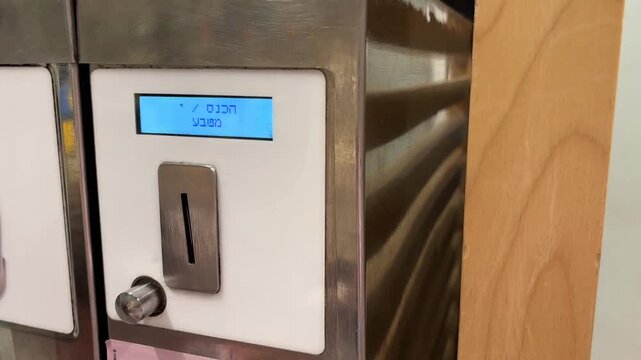 Child inserting coin into automatic ice cream vending machine with Hebrew text display screen showing startup message in commercial setting