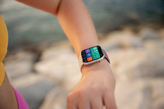 Woman checking fitness smartwatch during outdoor workout