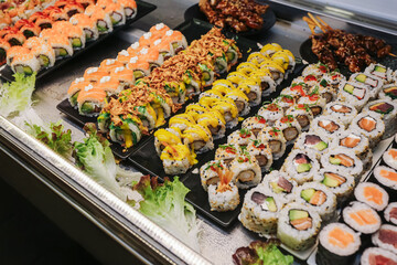 Fresh sushi assortment display. Japanese food background in restaurant counter. Colorful rolls...