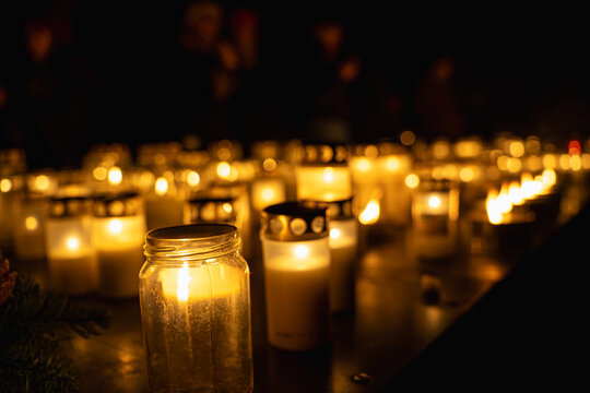 Candlelit memorial with glowing votive candles at night