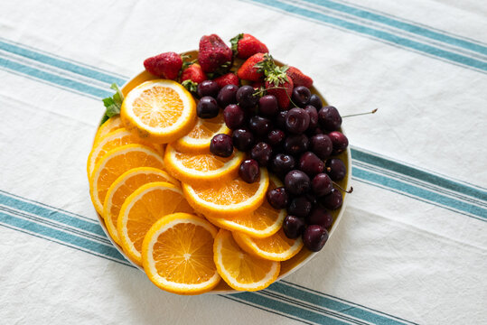 Fresh fruit platter with oranges, cherries, and strawberries
