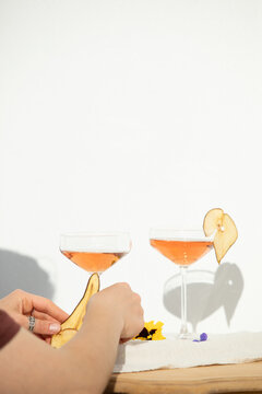 Two rose wine glasses with summer cocktails and dried fruit appetizers