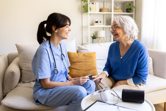Nurse visiting elderly woman at home taking oxygen saturation level