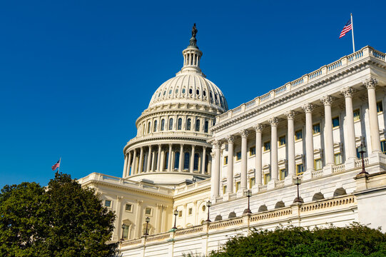 Capitol building in Washington DC. Historic Capitol shows federal government. Capitol dome defines American architecture. USA flag rises above Capitol.