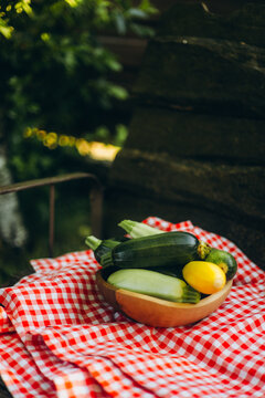 Freshly harvested zucchini in wooden bowl on table