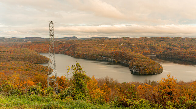 Colorful autumn river valley landscape under cloudy sky