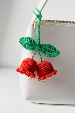 Close-up crocheted flower keychain on white handbag