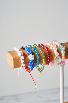 Colorful beaded bracelets on wooden display with copy space