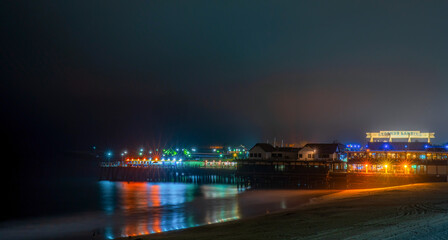 Fototapeta premium Redondo Beach pier illuminated at night with colorful reflections on the water