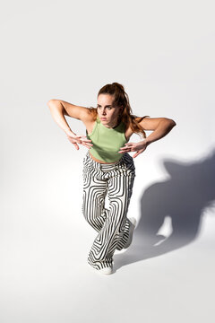 Urban woman dancer in striped pants casting dramatic shadow