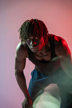 African athlete in dramatic red and green studio light
