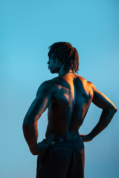 Muscular African man posing shirtless from the back