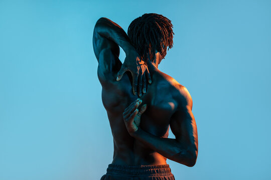 African man stretch Muscular back against blue background
