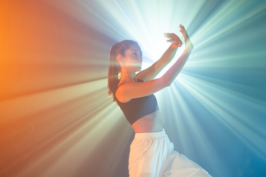 Latin woman urban dancer posing in colorful stage light