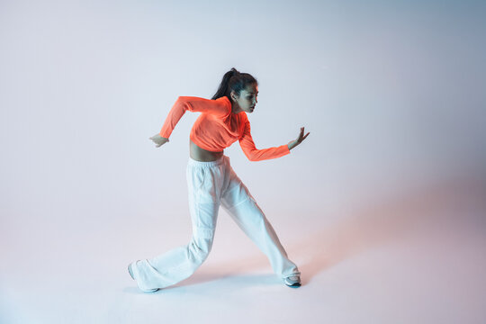 Latin woman urban dancer in vibrant studio light