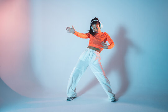 Latin woman urban dancer wearing headphones in studio