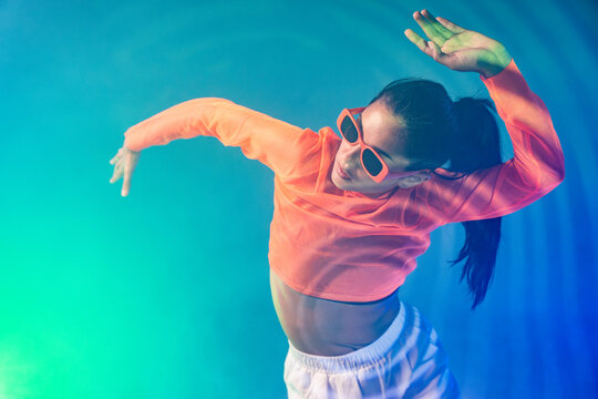 Latin woman urban dancer in coral top and sunglasses